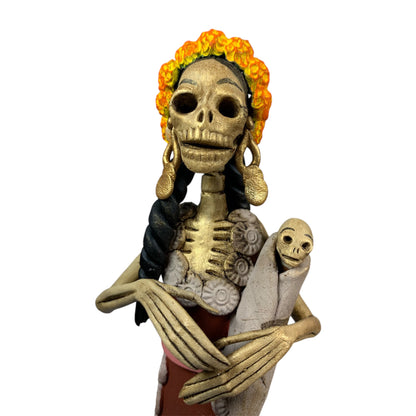 Catrina con bebé esculpida en barro por maestros artesanos de capula Michoacán